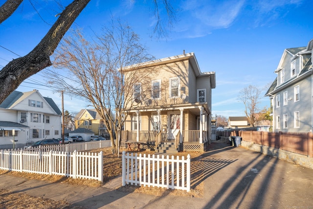 view of front facade with covered porch, a fenced front yard, and a residential view