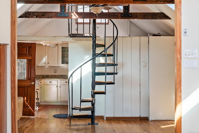 stairs with lofted ceiling with beams and hardwood / wood-style flooring