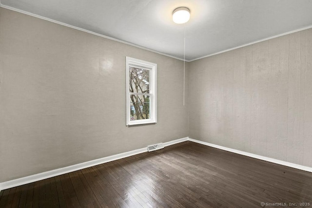 unfurnished room with dark wood-type flooring, visible vents, crown molding, and baseboards