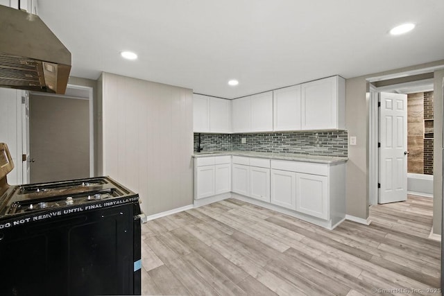 kitchen featuring black gas stove, light wood-type flooring, tasteful backsplash, and ventilation hood