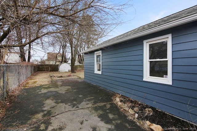 view of home's exterior featuring a storage unit, a patio area, a fenced backyard, and an outdoor structure