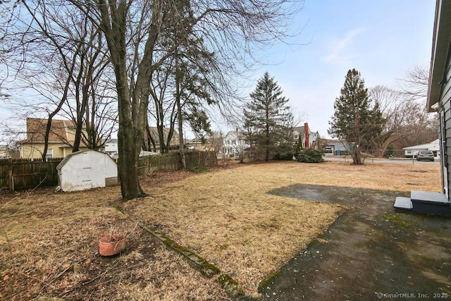 view of yard with an outbuilding, fence, and a storage unit