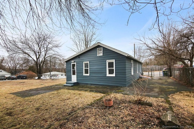 view of side of home with fence and a lawn