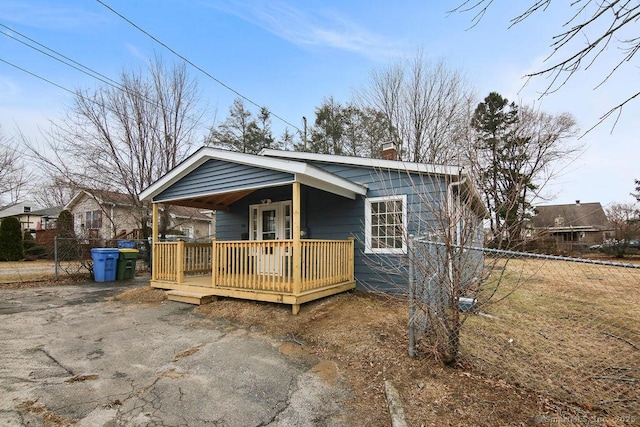 view of front of property with a chimney, fence, and a deck