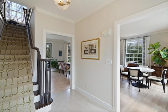 entrance foyer featuring light wood finished floors, stairway, crown molding, and baseboards