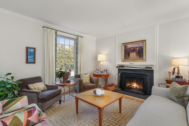 living area with crown molding, a fireplace with flush hearth, and wood finished floors