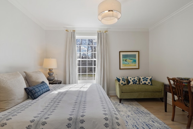 bedroom with wood finished floors and ornamental molding