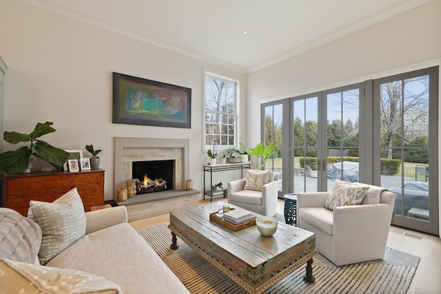 living room with a premium fireplace, wood finished floors, and ornamental molding