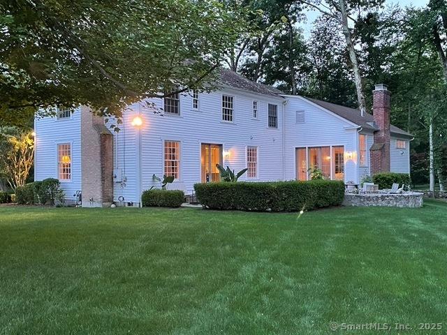 view of front of home featuring a yard and a chimney