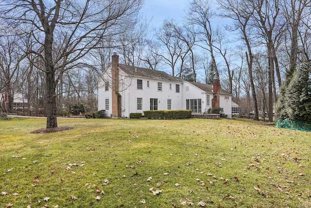 colonial house with a front yard and a chimney