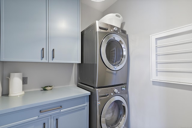 laundry area featuring cabinet space and stacked washer and dryer