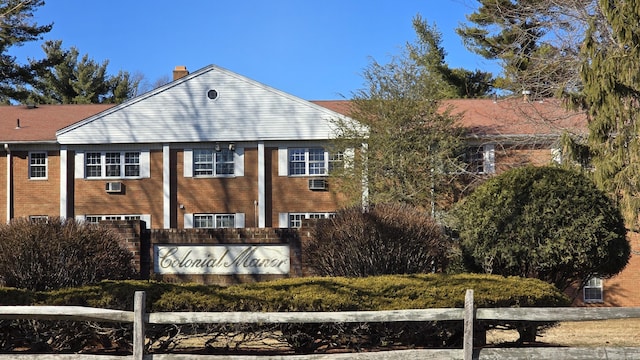 exterior space featuring brick siding, fence, and a chimney