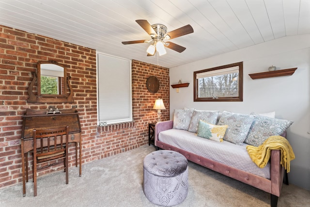 living area featuring carpet floors, brick wall, wood ceiling, and a ceiling fan