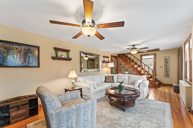 living room featuring stairs, wood finished floors, and a ceiling fan