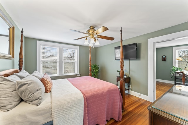 bedroom with ceiling fan, baseboards, and wood finished floors