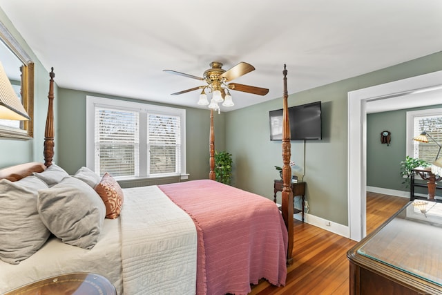 bedroom featuring a ceiling fan, baseboards, and wood finished floors