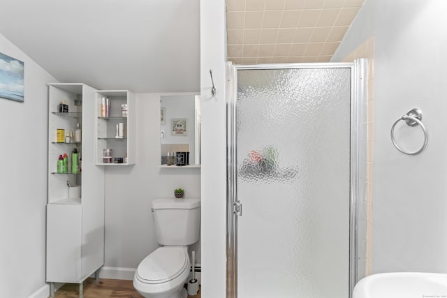 full bathroom with toilet, a shower stall, baseboards, and wood finished floors