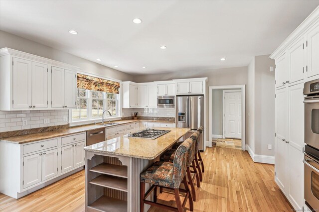 kitchen featuring white cabinetry, stainless steel appliances, and open shelves