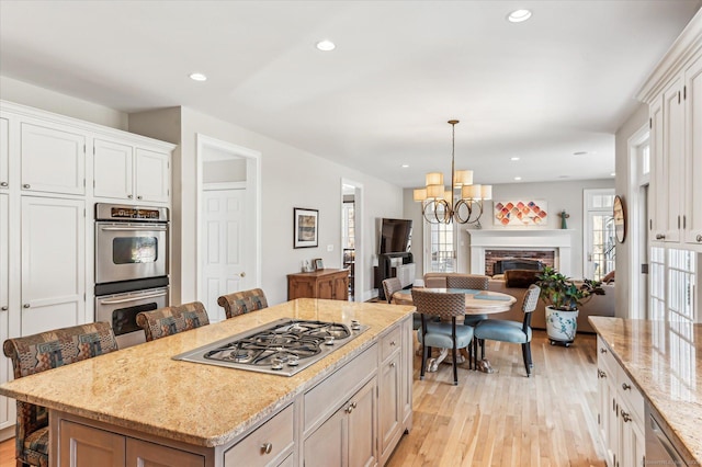 kitchen featuring an inviting chandelier, appliances with stainless steel finishes, open floor plan, and light wood finished floors