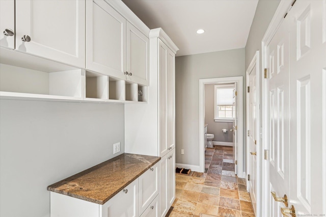 interior space with stone tile floors, recessed lighting, and baseboards