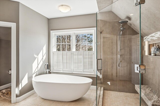 full bath featuring a soaking tub, baseboards, a stall shower, and tile patterned floors