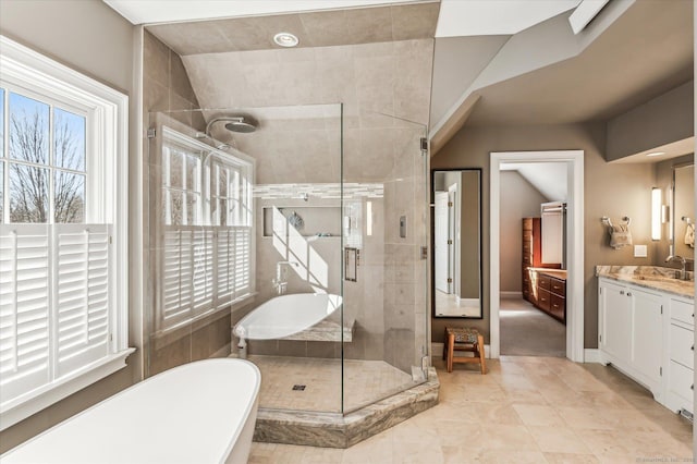 bathroom with plenty of natural light, a stall shower, a freestanding bath, and vanity