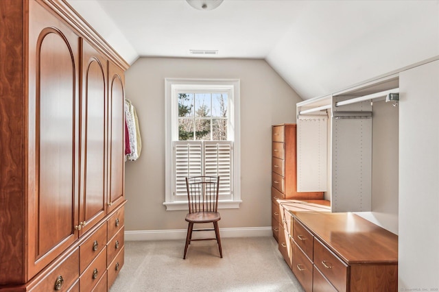 spacious closet with visible vents, light colored carpet, and vaulted ceiling