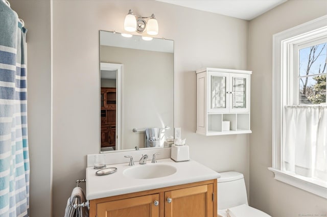 bathroom with vanity, a shower with shower curtain, and toilet