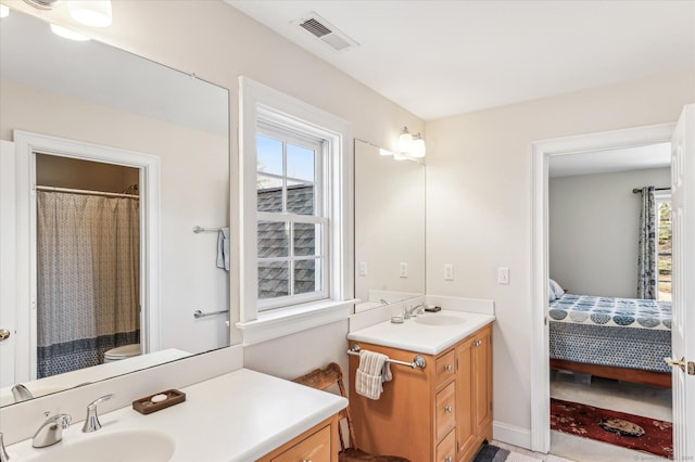 ensuite bathroom with vanity, plenty of natural light, visible vents, and ensuite bathroom