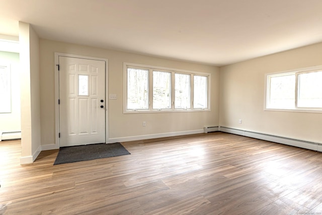 entryway with baseboard heating, baseboards, and wood finished floors