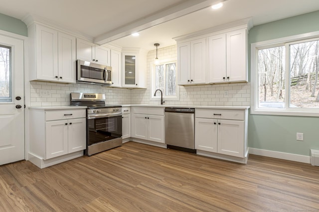 kitchen featuring white cabinetry, light wood finished floors, and appliances with stainless steel finishes