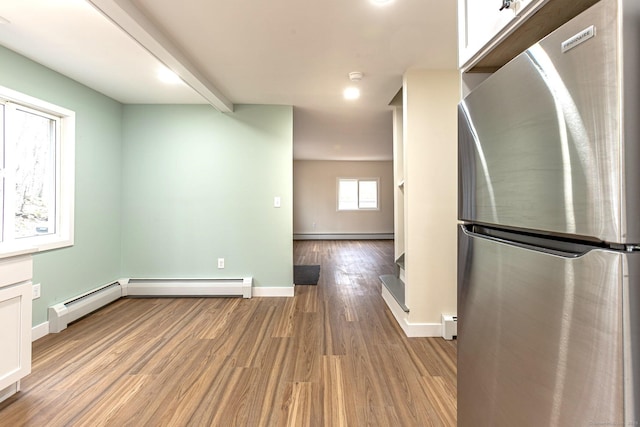 kitchen with beamed ceiling, wood finished floors, baseboards, and freestanding refrigerator