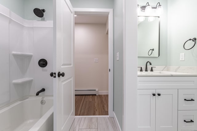 full bath with vanity, wood finished floors, baseboards, tub / shower combination, and baseboard heating