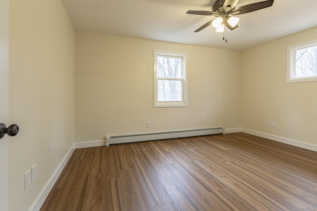 unfurnished room with a ceiling fan, a baseboard heating unit, baseboards, and wood finished floors