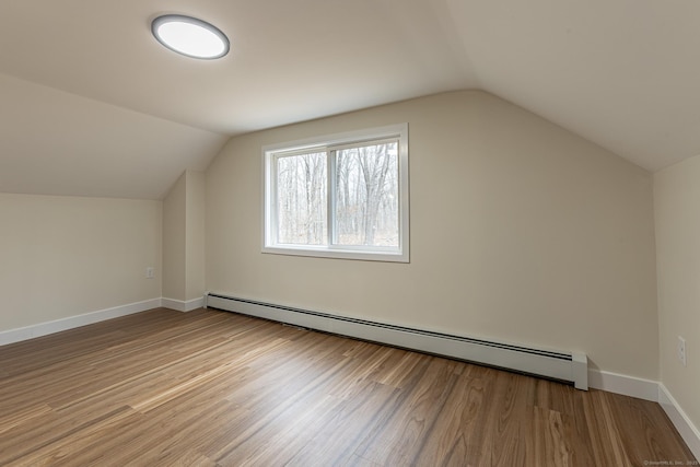 bonus room with lofted ceiling, wood finished floors, baseboards, and baseboard heating