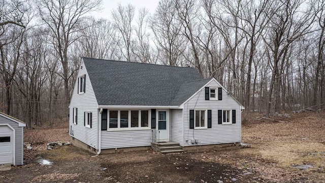 cape cod house with entry steps and a shingled roof