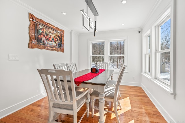 dining area featuring light wood finished floors, baseboards, crown molding, and recessed lighting