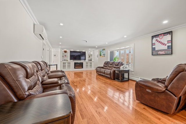 living room featuring built in shelves, an AC wall unit, ornamental molding, light wood finished floors, and a glass covered fireplace