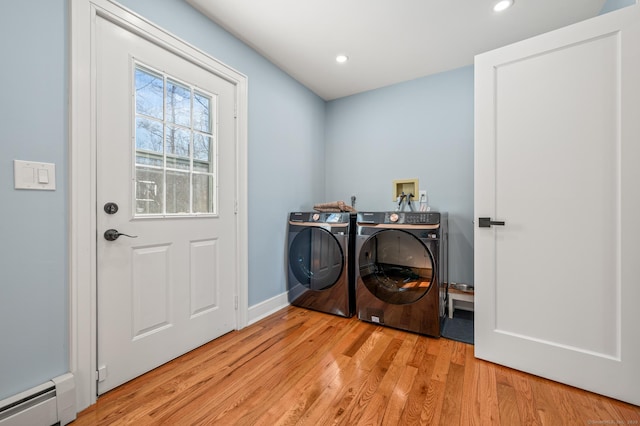 clothes washing area with washing machine and clothes dryer, a baseboard radiator, recessed lighting, light wood-style flooring, and laundry area