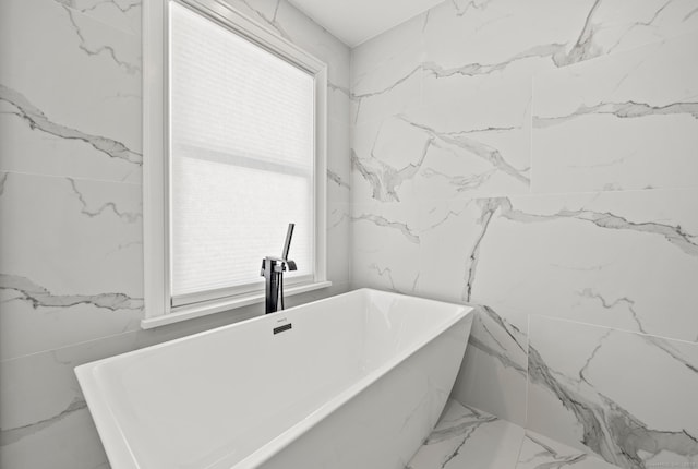 full bath with a sink and stone wall