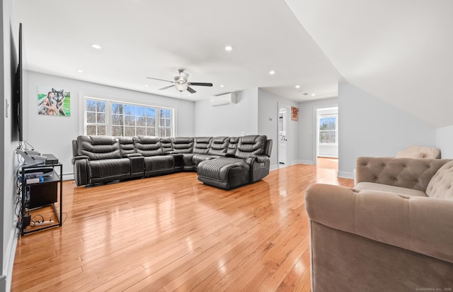 living area featuring baseboards, recessed lighting, a wall unit AC, and light wood-style floors