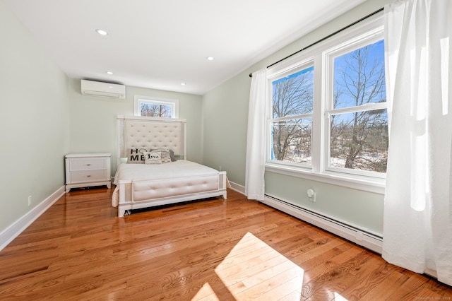 bedroom featuring a baseboard radiator, light wood-style flooring, recessed lighting, baseboards, and an AC wall unit