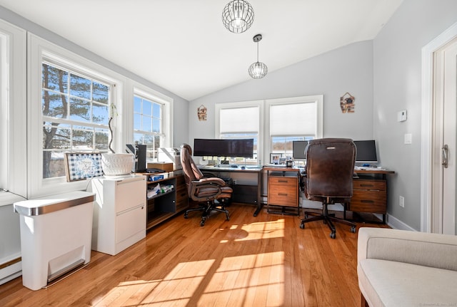 home office featuring a baseboard radiator, light wood-style flooring, and vaulted ceiling