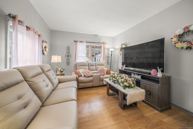 living room featuring vaulted ceiling and light wood-type flooring