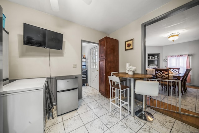 interior space featuring refrigerator, marble finish floor, a ceiling fan, and freestanding refrigerator