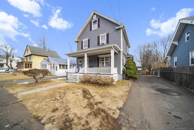 view of front of home with a porch and fence