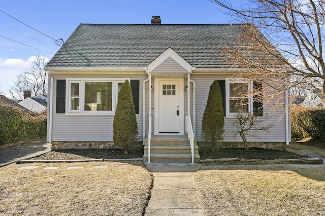 bungalow-style home with a shingled roof and a chimney