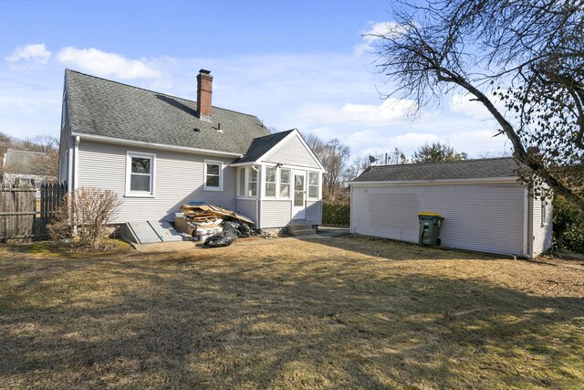 back of property with entry steps, a yard, a chimney, and roof with shingles