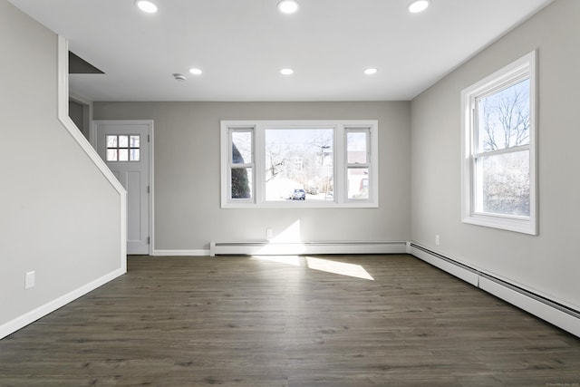 interior space with baseboard heating, a baseboard heating unit, dark wood finished floors, and recessed lighting