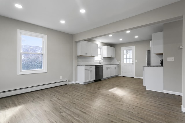 kitchen featuring white cabinets, decorative backsplash, dishwasher, wood finished floors, and a baseboard heating unit